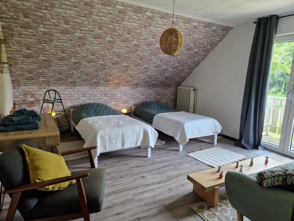 a room with three beds and a brick wall at Ruhige Ferienwohnung an der Vechte - Zweites Glûck in Nordhorn
