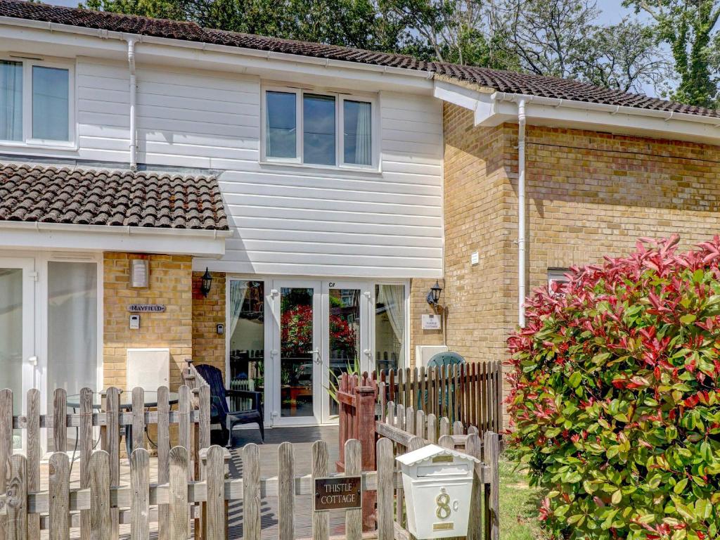 a house with a wooden fence in front of it at Thistle Cottage in Ryde