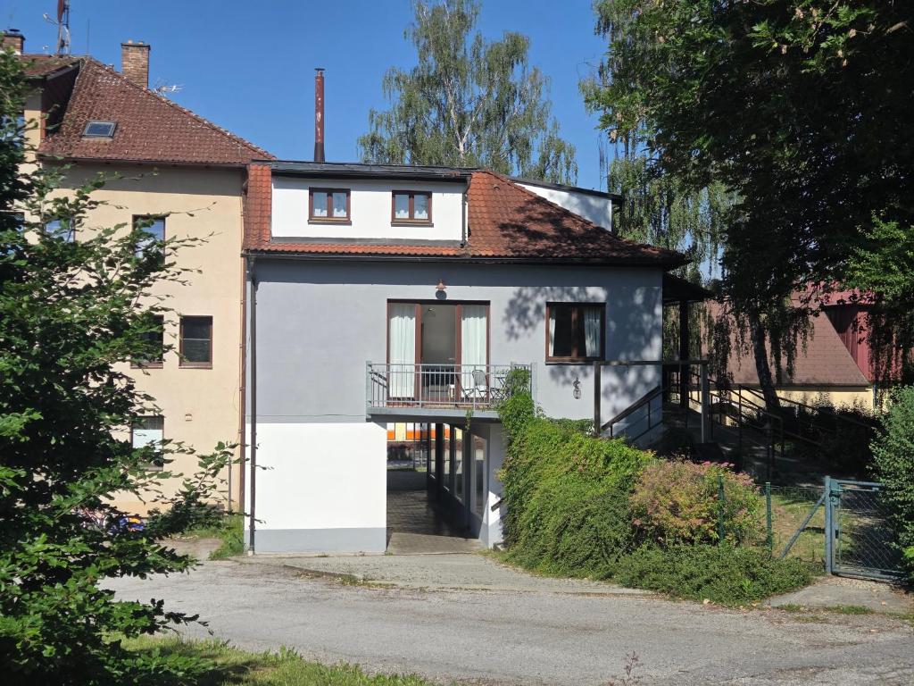 a white house with a balcony on a street at Pension Terezka in Frymburk