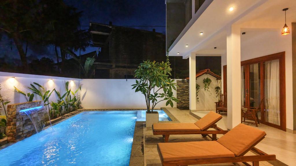 a swimming pool in a house with two chairs at Still Reef in Matara
