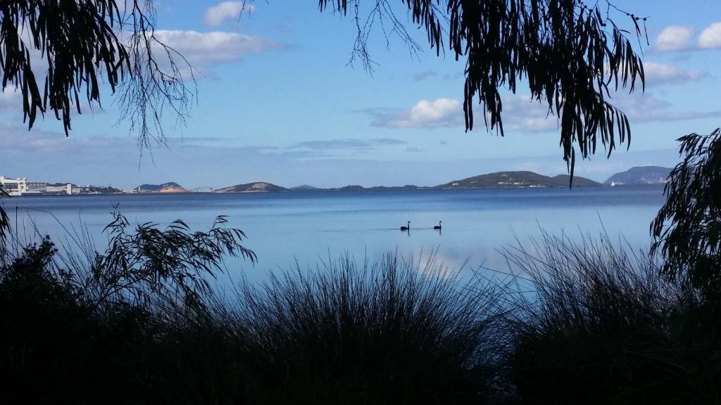 two boats on a lake with mountains in the distance at Lilacs Waterfront Villas & Cottages in Albany