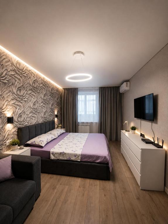 a bedroom with a bed and a couch at Ткачёва in Pavlodar