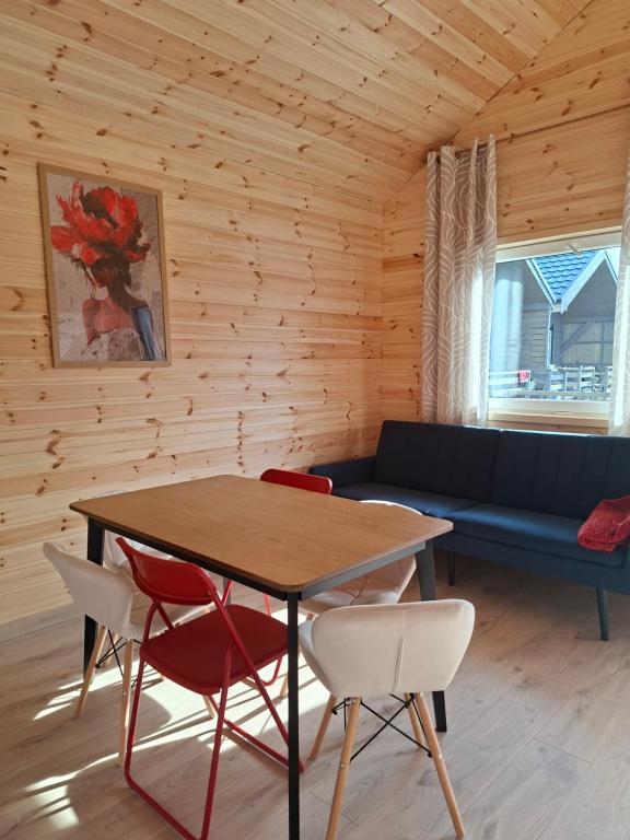 a room with a table and chairs and a couch at Sielska Przystań in Gąski