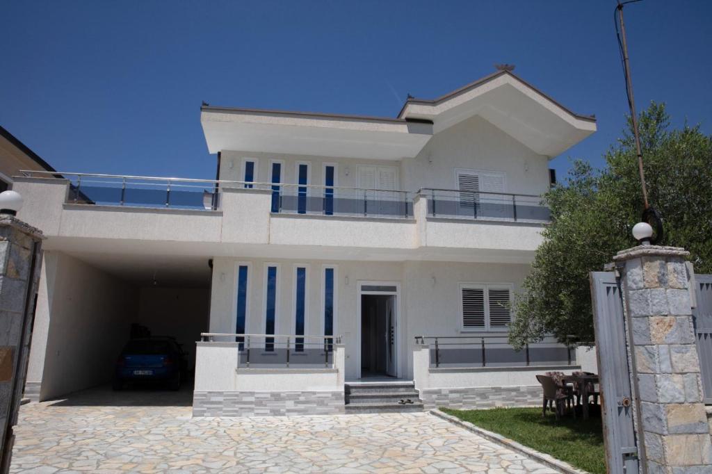 a white house with blue stripes on it at Miri House in Domje