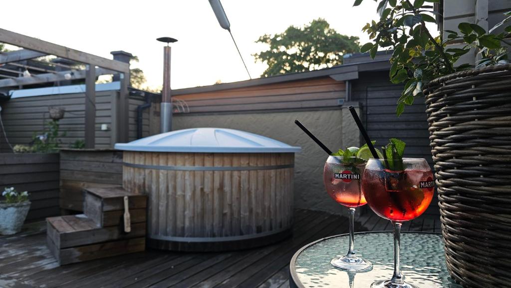 Zwei Weingläser stehen auf einem Tisch auf der Terrasse in der Unterkunft Real holiday feeling with sauna in Beddinge Strand