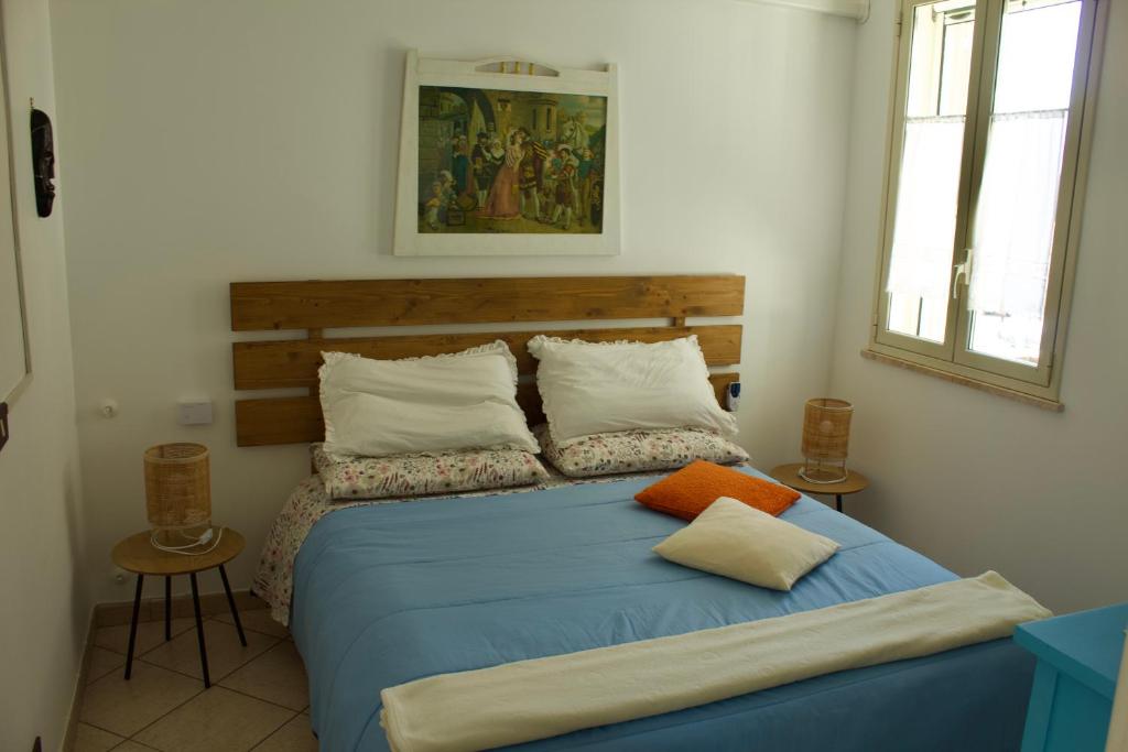 a bedroom with a blue bed with two pillows at Casa Arcobaleno in Marsala