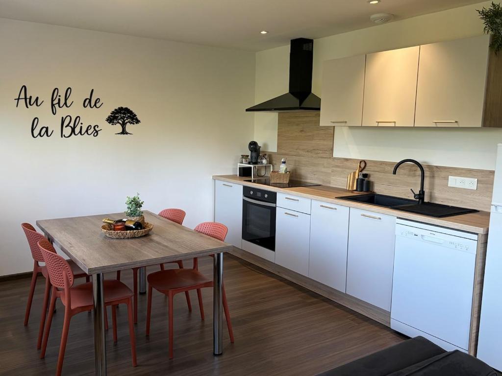 a kitchen with a table and chairs and a sink at Au fil de la Blies in Bliesbruck