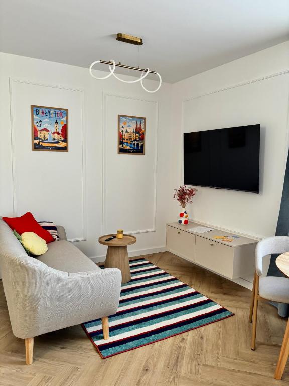 a living room with a couch and a flat screen tv at WOW Apartament in Białystok