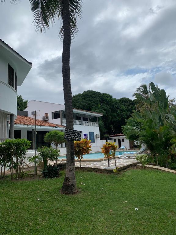 a palm tree in front of a house with a sign on it at MJ Marina in Mtwapa
