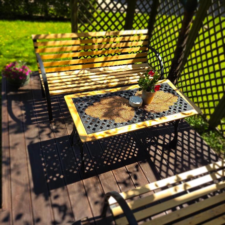 a picnic table with a potted plant on it next to a bench at Nida Amber in Nida
