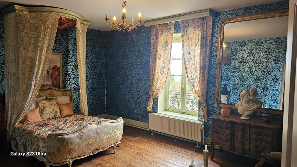 a bedroom with a canopy bed and a window at Chambre Napoléon III in Fleuriel