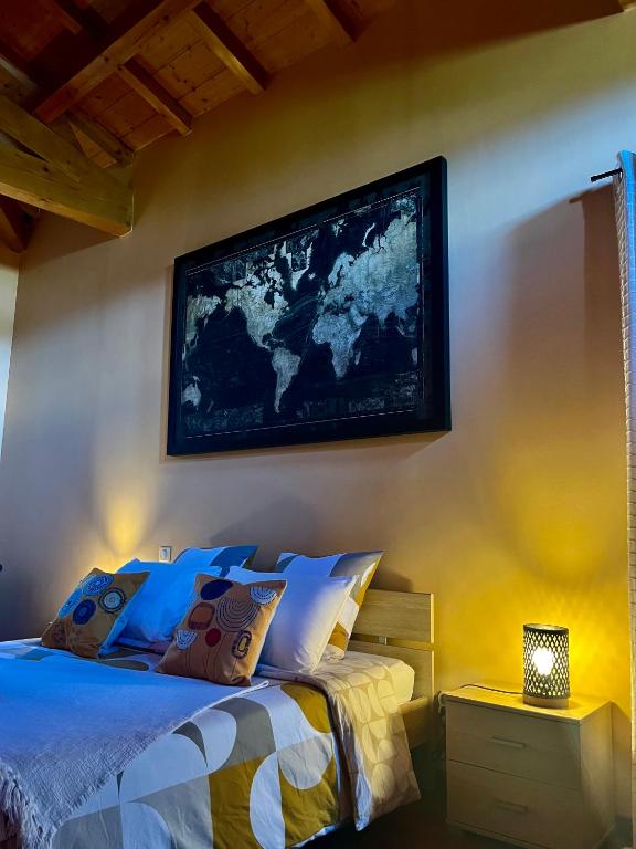 a bedroom with a bed with a map on the wall at Le Domaine d'Adrien in Larnage