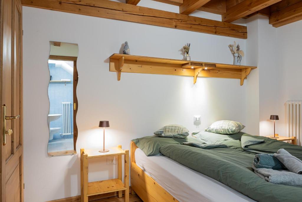 a bedroom with a bed and a shelf on the wall at La Culla Stube in Padola