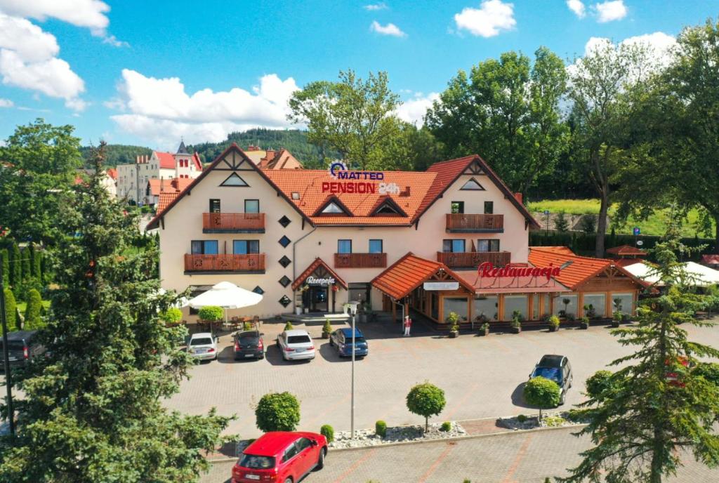 a large building with a parking lot in front of it at MATTEO Pensjonat Apartamenty in Duszniki Zdrój