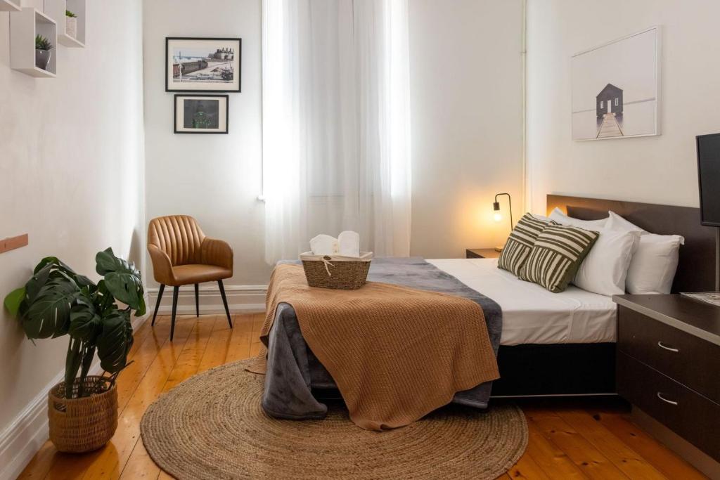 a bedroom with a bed with a table and a chair at The Beaconsfield Hotel in Fremantle