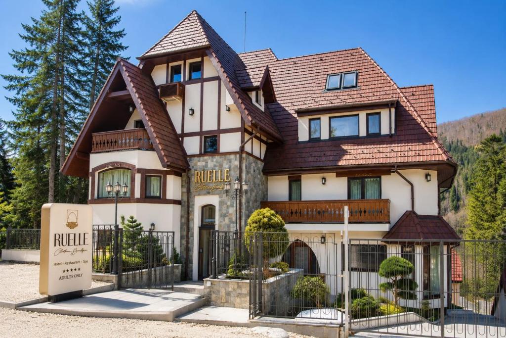 a large house with a fence in front of it at RUELLE Chateau Boutique- adults only in Sinaia