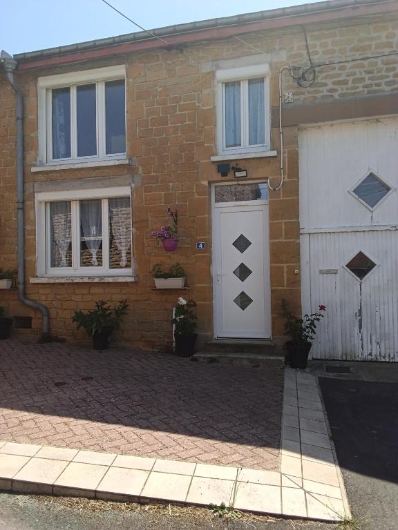 a brick house with a white door and a garage at Gîte du piémont in Mouzon