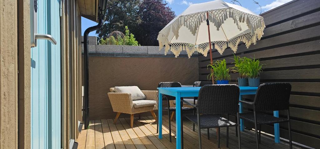 a blue table with chairs and an umbrella on a patio at Ocean Breeze next to the Beach in Beddinge Strand