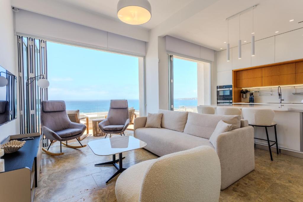 a living room with a couch and chairs and a kitchen at Olymp Luxury Residence in Kissonerga