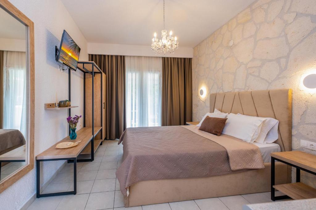 a hotel room with a bed and a chandelier at Μυρτιές-Mirties in Siviri