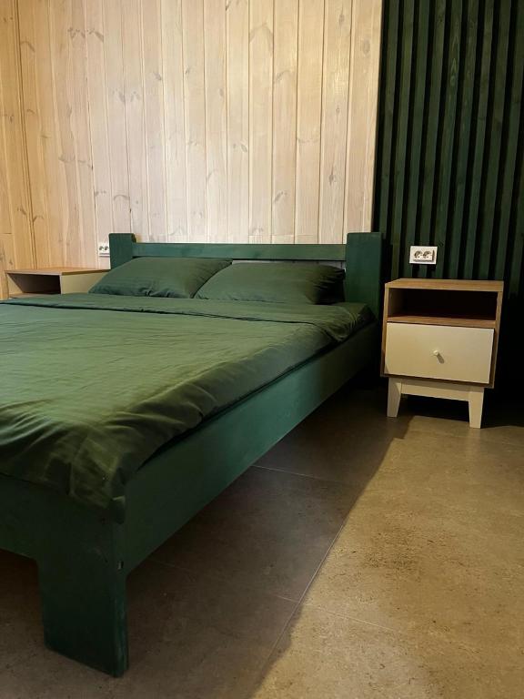 a green bed in a room with a night stand at Wald Haus in Pulʼmo