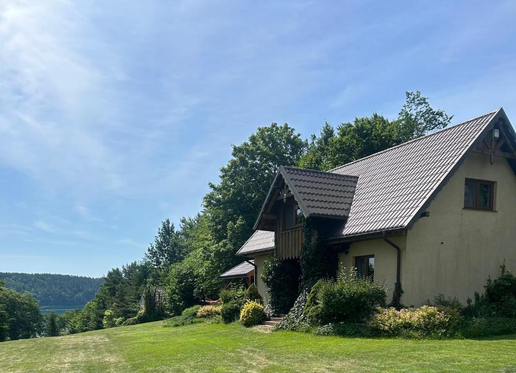 a house with a metal roof on a green field at HUBERTOWO in Borucino