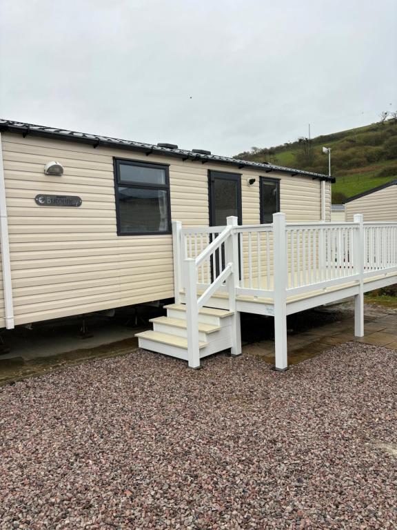a mobile home with a staircase and a porch at Dale 12 in Burgh Island