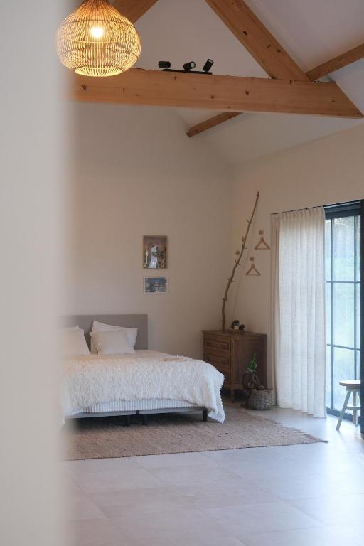 a bedroom with a bed and a wooden ceiling at Villa Hartebos in Kaprijke