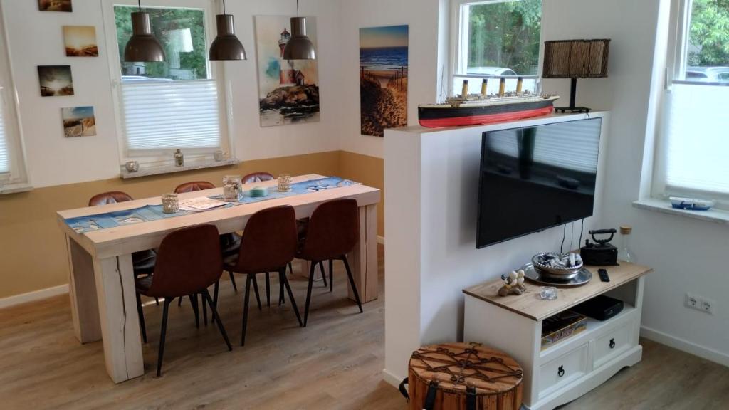 a room with a table with chairs and a television at Ferienhaus Happytime in Binz