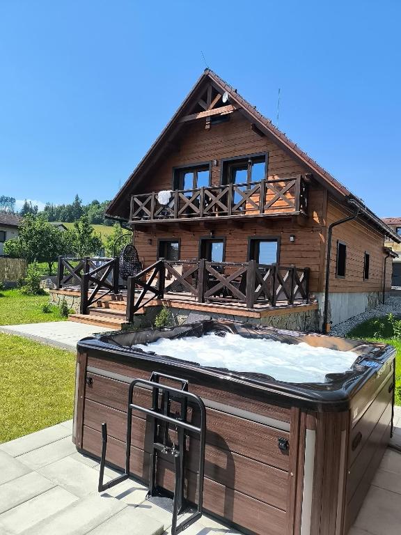 a hot tub on a deck in front of a house at Chata Valeriana Liptov in Ižipovce