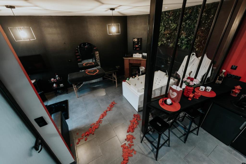 an overhead view of a bathroom with a tub and a table at La Maison Coquine Love Room Balnéo in Béthune