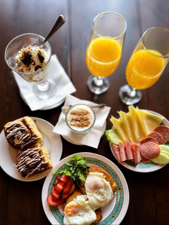 a table with plates of food and glasses of orange juice at Sintrivanis Mountain in Áno Skotína