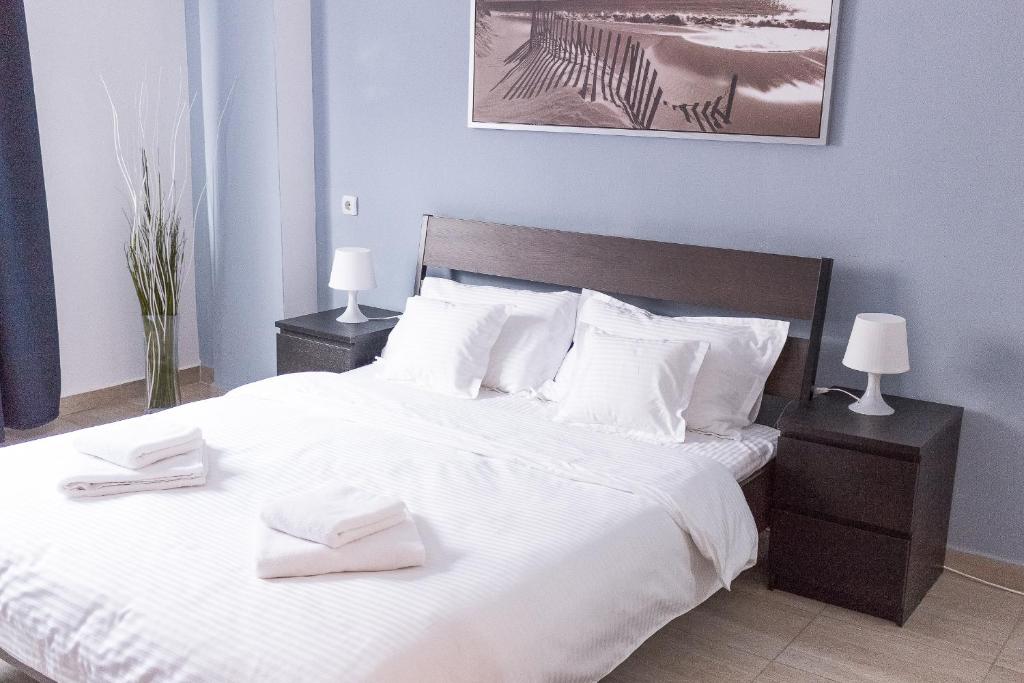 a bedroom with a large white bed with two lamps at Grand Central Accommodation - Beldiman in Bucharest