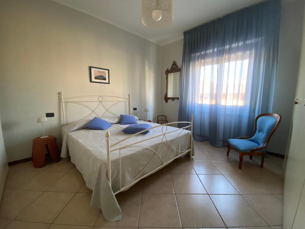 a bedroom with a bed and a blue chair at L'ora del tè in Cremona