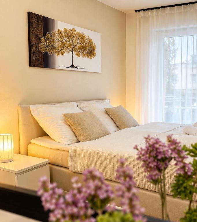 ein Schlafzimmer mit einem Bett und einem Baum an der Wand in der Unterkunft NOVA Living, Balkon, Nähe Altstadt & kostenlose Tiefgarage in Würzburg