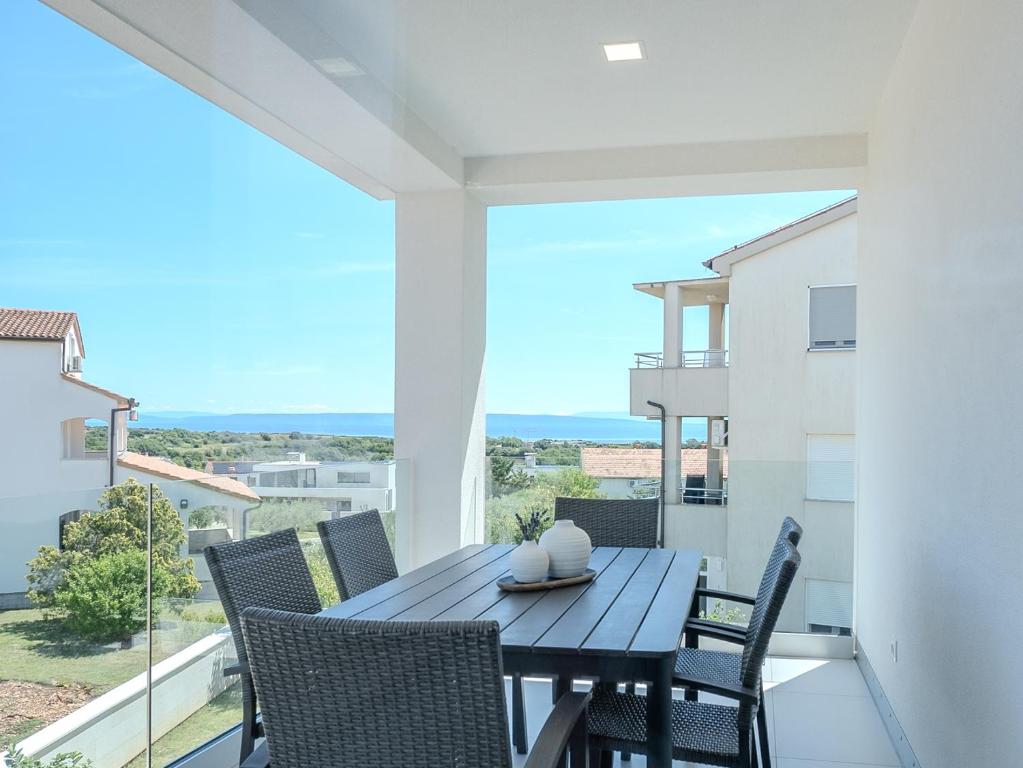 a dining table on a balcony with a view of the ocean at Apartment Rahat in Ližnjan