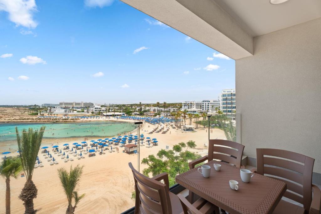 a dining room with a view of a beach at Kritamo Suites Sandy Bay in Ayia Napa