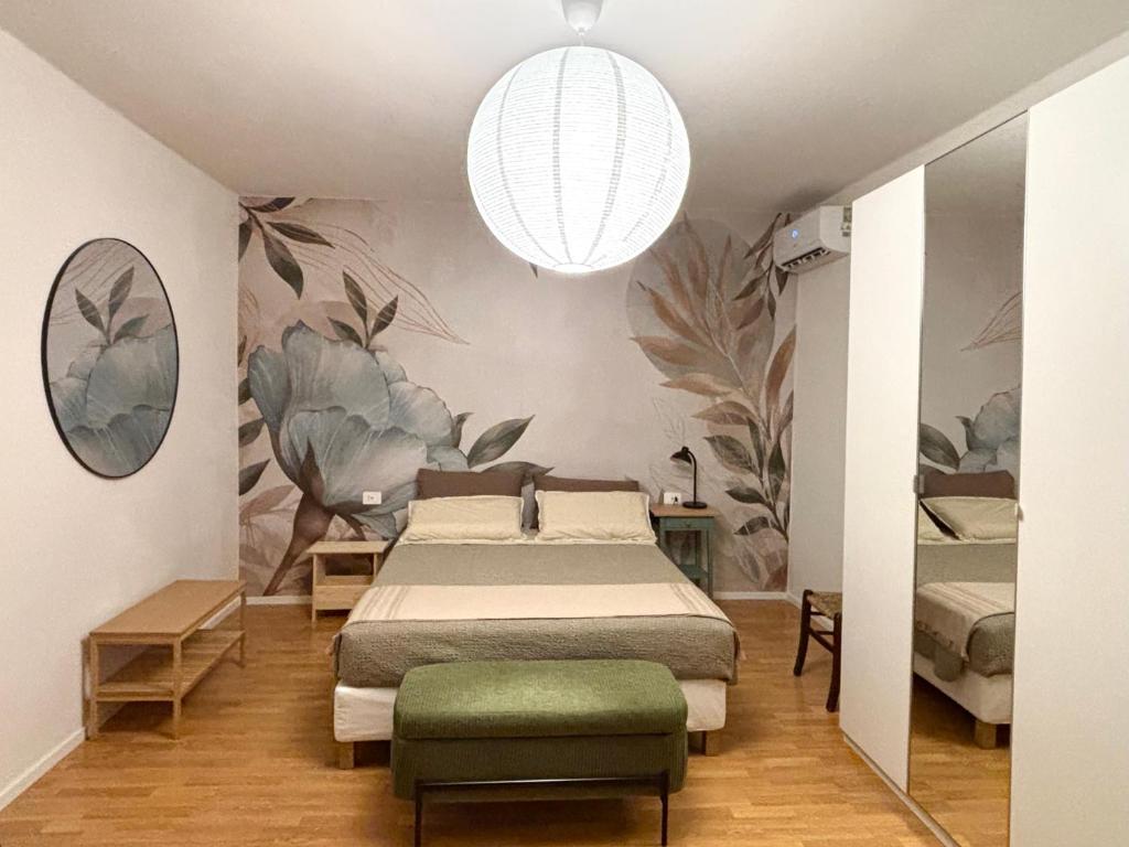 a bedroom with a bed and a green chair at Nella Corte - La Casetta in Corte Franca