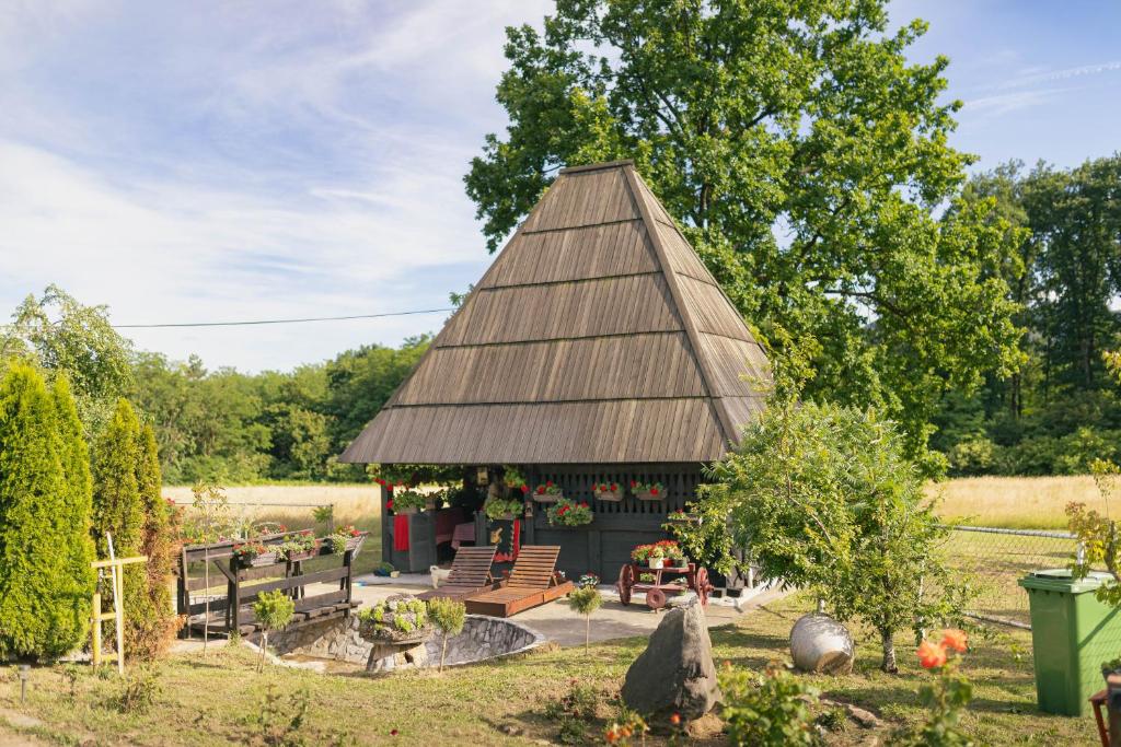 a gazebo in a garden with a tree at Brvnara Jez in Kraljevo