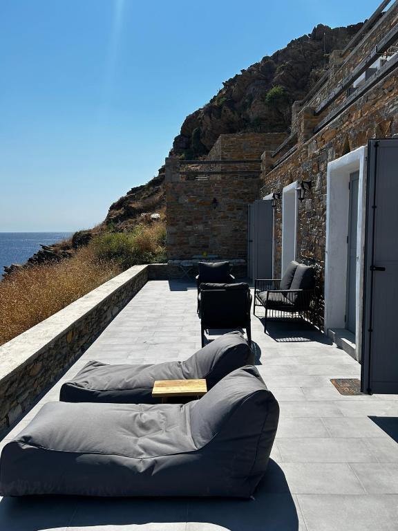 a row of bean bags on a patio next to the ocean at Salty Rock - Kythnos Suite in Kithnos