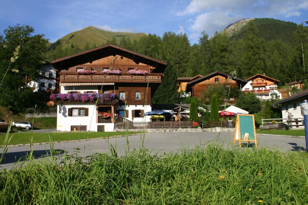 ein Gebäude in einer Stadt mit Bergen im Hintergrund in der Unterkunft Gasthof "Zur Gemütlichkeit" in Bschlabs
