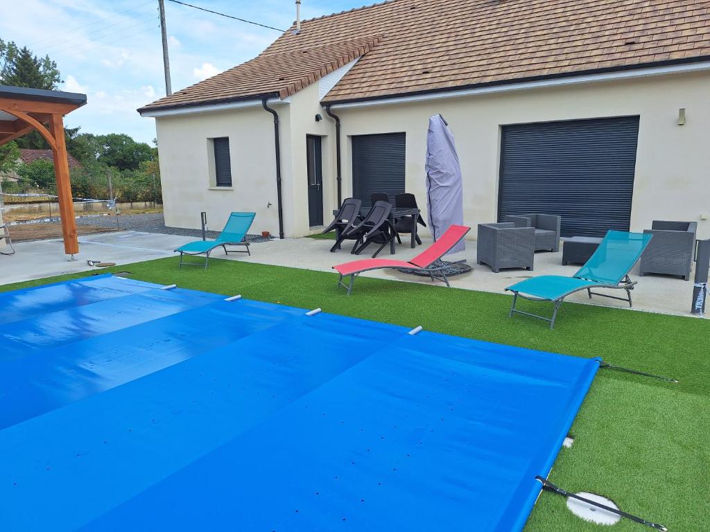 a yard with a pool and chairs and a house at le pavillon in Bonnat