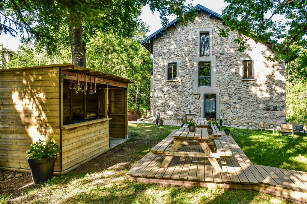 a picnic table in front of a stone building at Villa du Parc le Lilas in Formiguères