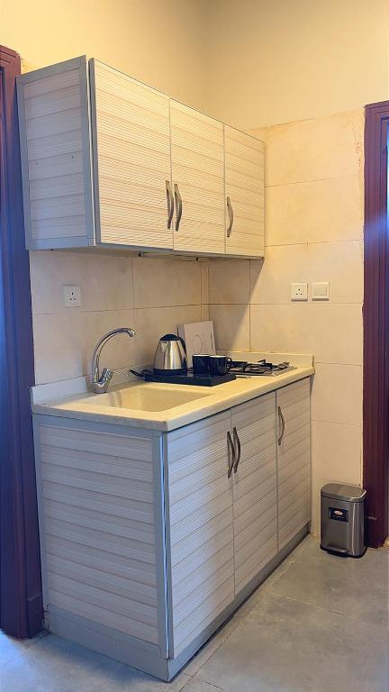a kitchen with a sink and a stove and cabinets at أوريانا oRIANA in Jeddah
