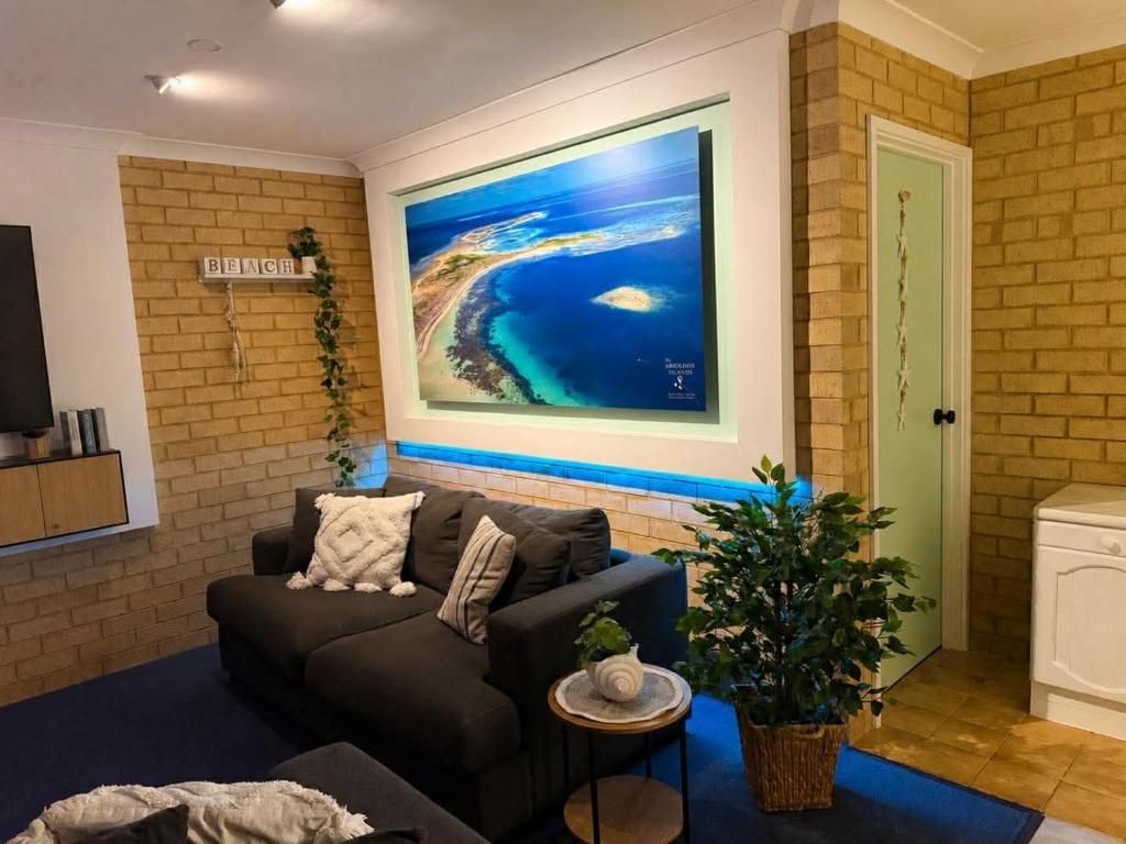 a living room with a couch and a painting on the wall at Champion Bay Coastal Stay in Geraldton