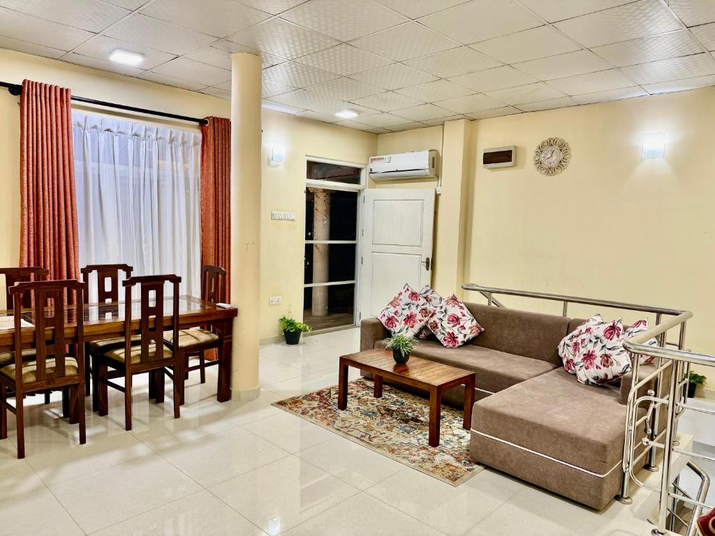 a living room with a couch and a dining room at Judewin villa Negombo in Negombo