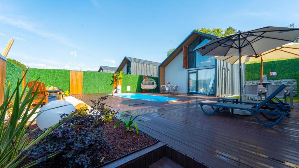 a wooden deck with a chair and an umbrella at JUNGLOW Sapanca in Sapanca