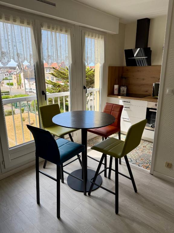 a table and chairs in a room with a kitchen at Escale Berckoise Studio Cosy Proche des Phoques in Berck-sur-Mer