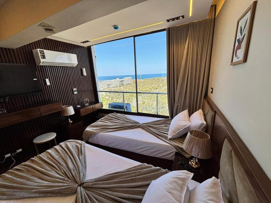 a hotel room with two beds and a large window at Montaza City in Alexandria