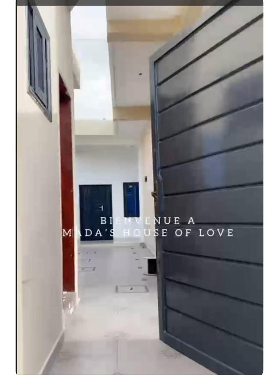 a door with the words beware a house of love at Mada's House F H L in Abomey-Calavi